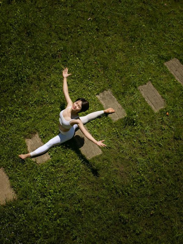Person stretching in a bright, open space, symbolizing flexibility and energy.